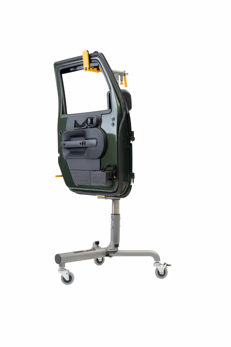 Green car door mounted on a gray rolling stand with wheels against a white background.