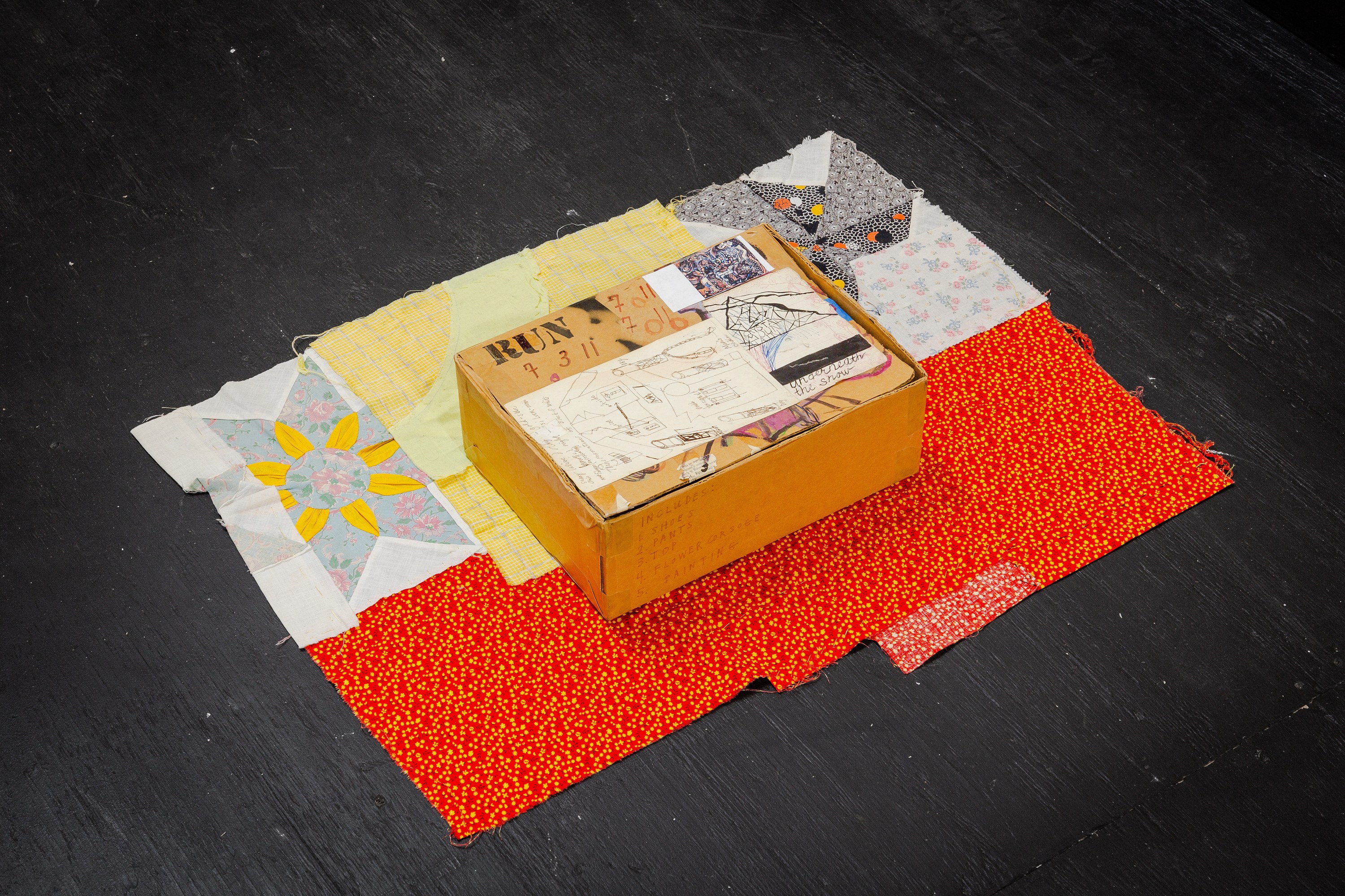 Susan Cianciolo, Adult Outfit Kit , 2012, Cardboard box with Run 7 shoes, pants, top, flower corsage, painting, 4 ½ × 12 ½ × 9 ¼ in