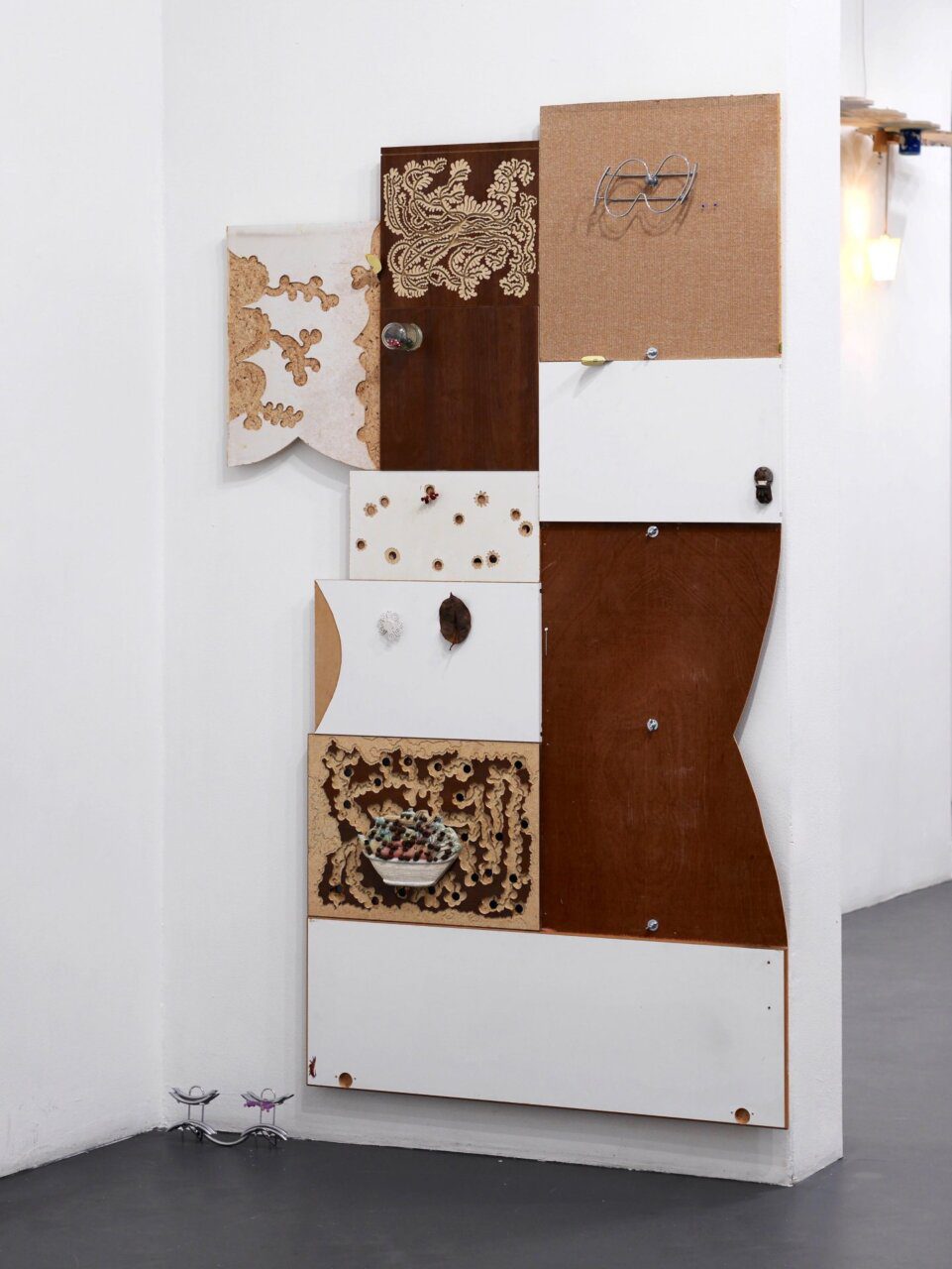 dylan ray arnold, Kitchen-Floor is Lava, 2025, Furniture-boards, wall-panel, knives, glass jar, dice, pumice, sticker, trivet, handles, polettes, dry leaf. Courtesy of the artist and Sculptor Gallery.