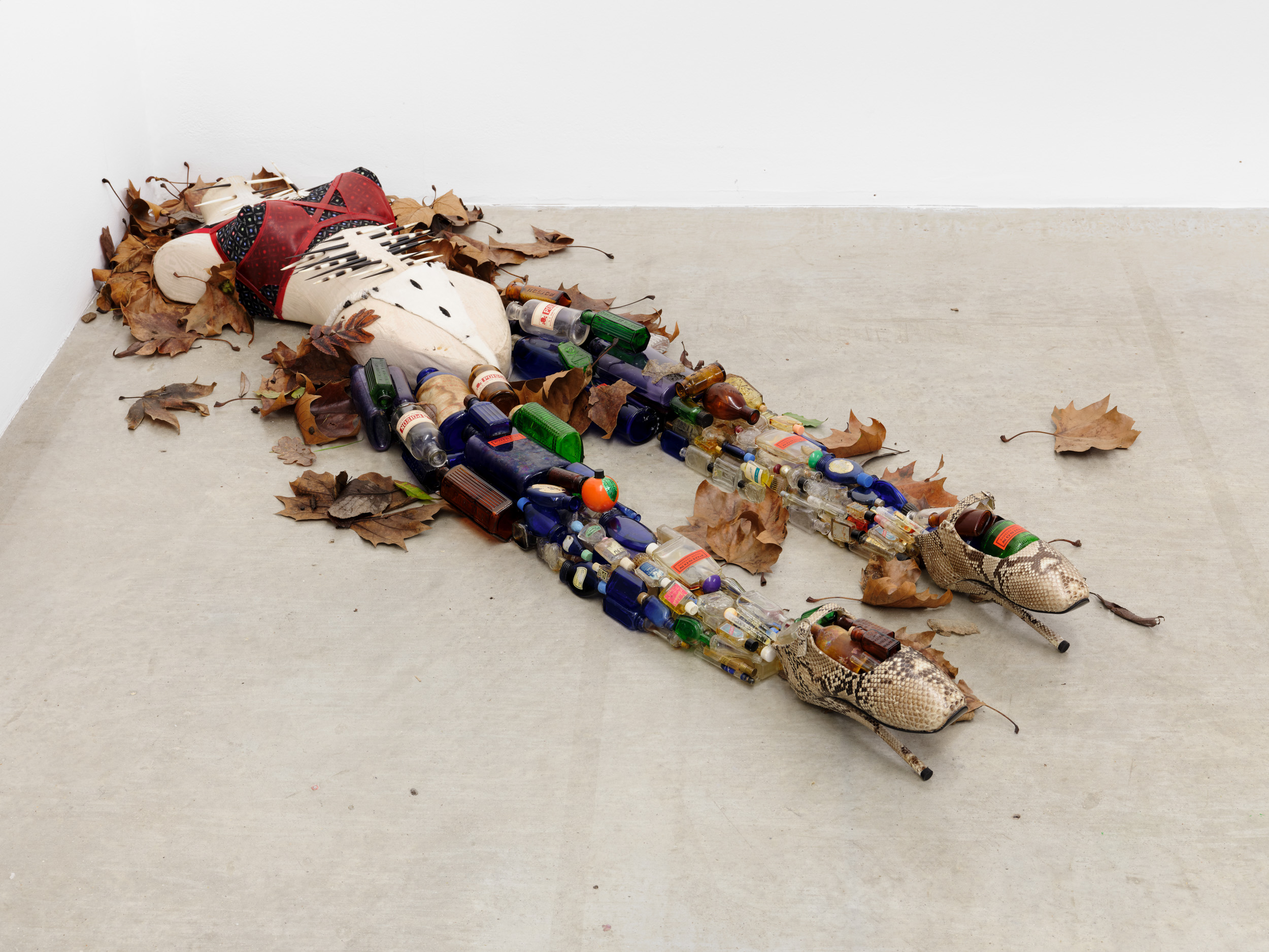 Women’s History Museum, Mon fantasme est un poison, 2026, 1930s faux moire Hindsgaul bust, 1920s faux Ermine fabric, African porcupine quills, 1890s French Calico bra layered with clear red leather, antique perfume bottles, antique poison bottles and liquor flasks, snakeskin-covered ballet fetish shoes, leaves,
160 × 43.2 × 18 cm. Courtesy of the artist and Soft Opening.