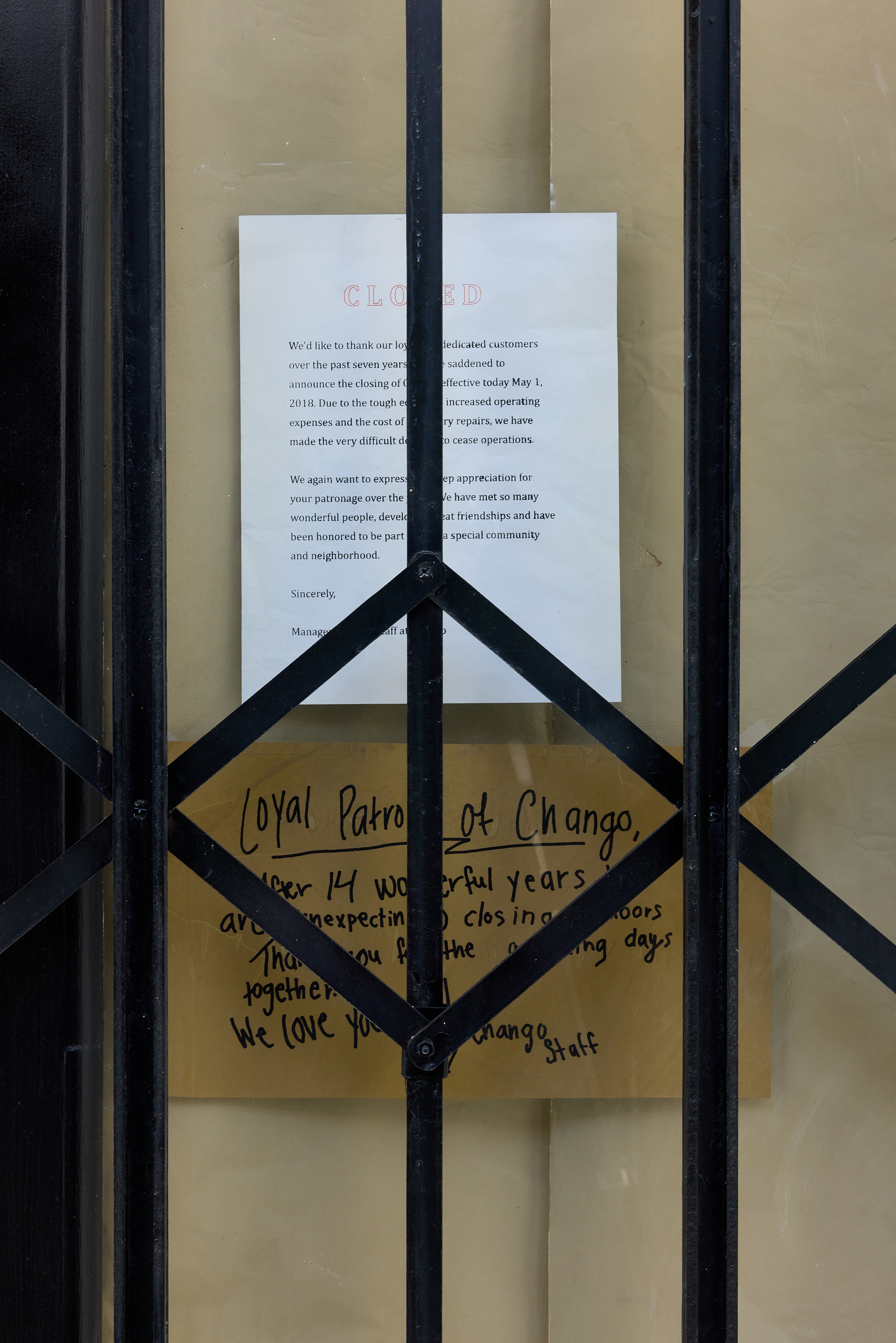 Fiona Connor, Closed Down Clubs, Chango Coffee wooden door frame, polycarbonate, hardware, folding gate, silk screen on coated aluminium foil and vinyl, tape, surface coatings 223.5 × 111.8 × 15.2 cm – 88 × 44 × 6 in 2022. Courtesy of the artist and Maureen Paley.