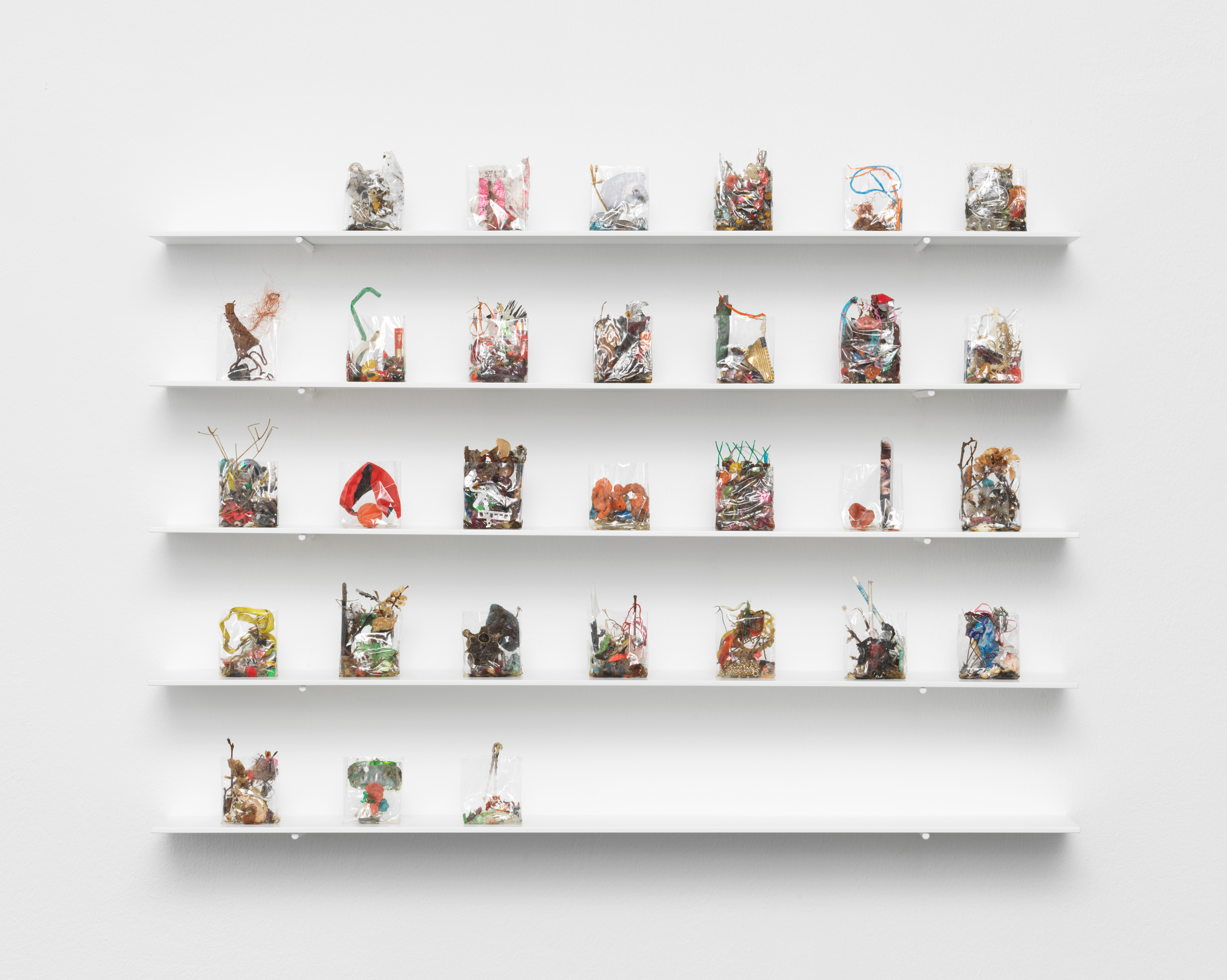 Yuji Agematsu, Zip: 01-01-2024 – 12-31-2024, mixed media in cigarette pack cellophane wrappers on powder- coated aluminum shelves 366 wrappers, each ca. 5.7 x 5.4 x 1.9 cm 62 shelves, each 0.5 x 84 x 12 cm Detail: 04-01-2024 – 04-30-2024. Courtesy of the artist and Galerie Buchholz.