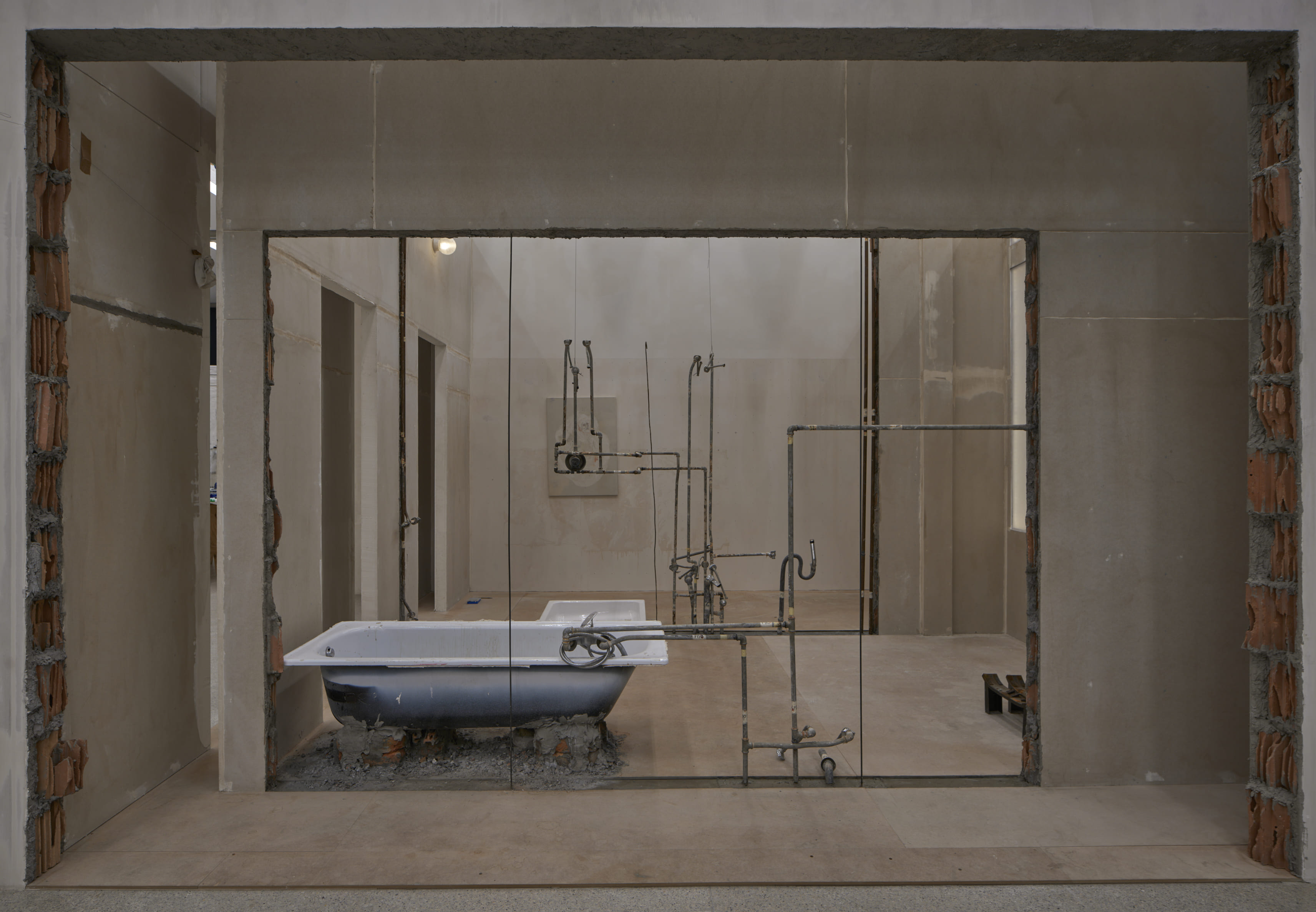 Tolia Astakhishvili, my emptiness, 2025–26, construction material, excavated pipes, bathtub, shower tray, mirrors, light 482.5 x 643 x 431 cm. Courtesy the artist, LC Queisser and Emalin. Photo: Tolia Astakhishvili Studio