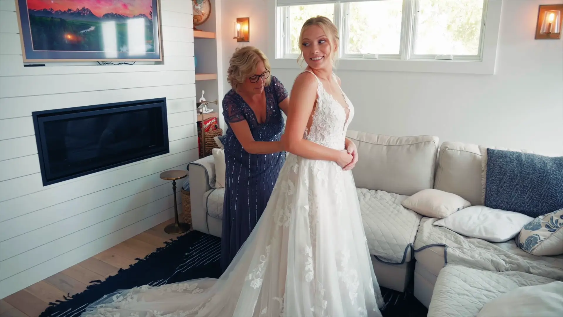In this candid moment from the wedding video, Lindsey smiles as a woman helps her with her dress. The cozy interior of a room at Ciccone Vineyard and Winery forms the backdrop, adding warmth to this special day.