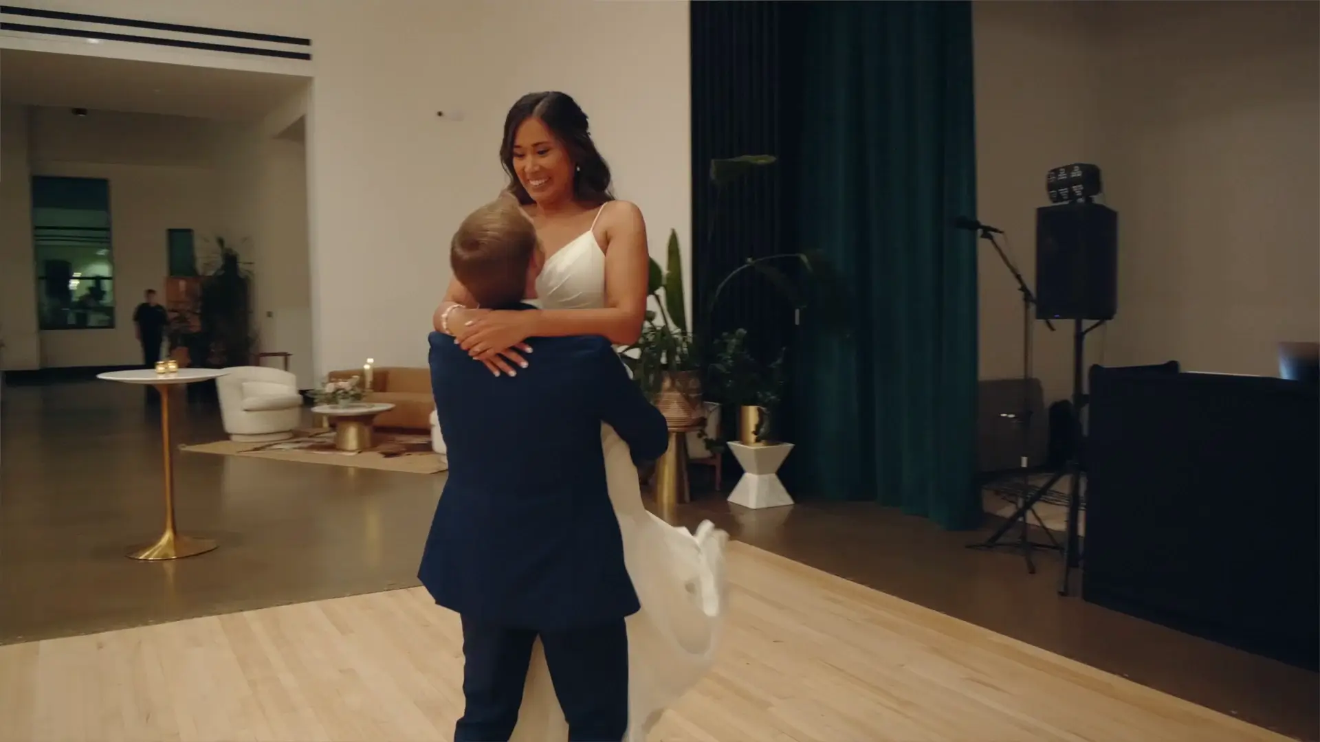Bride Sherilyn and groom Alex share a joyful dance moment, with Sherilyn lifted in Alex's arms, captured for their wedding videography in Grand Rapids, Michigan.