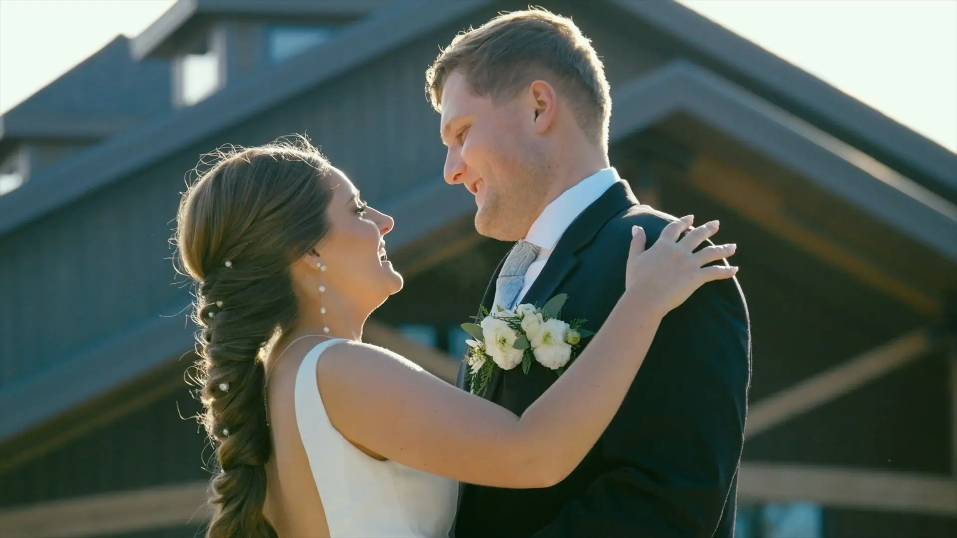 Sarah & Drew smile dance and smile at eachother in front of the Black River Barn on their wedding day