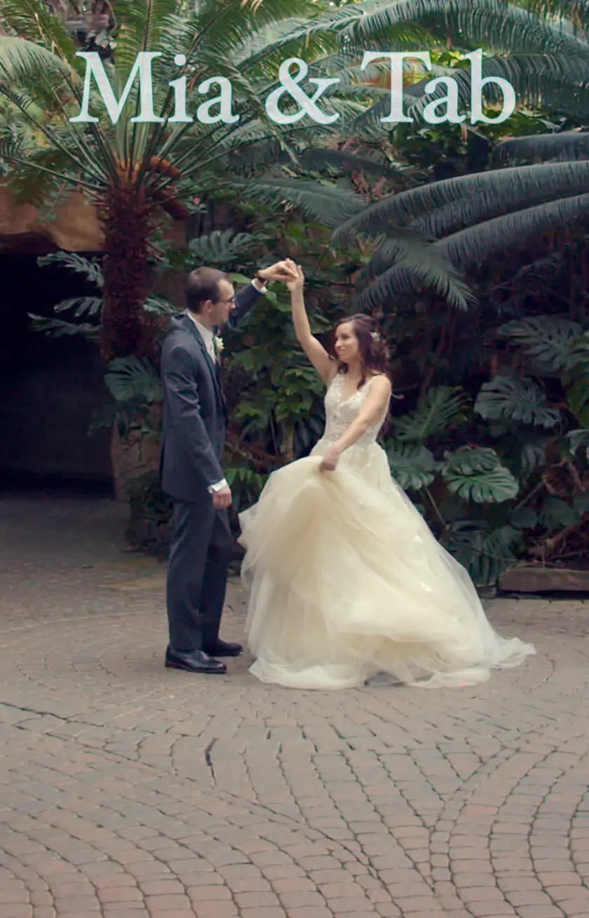 Bride and groom dancing in a lush garden setting during their wedding.