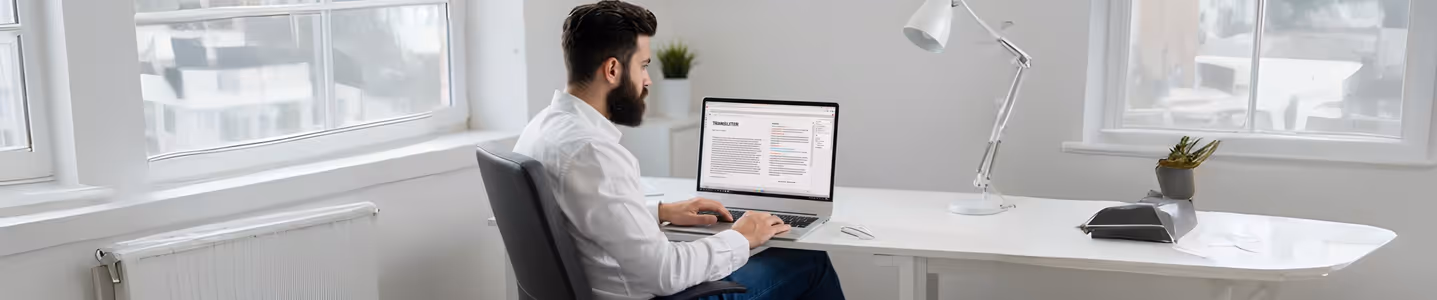 Homem trabalhando em tradução de texto no laptop