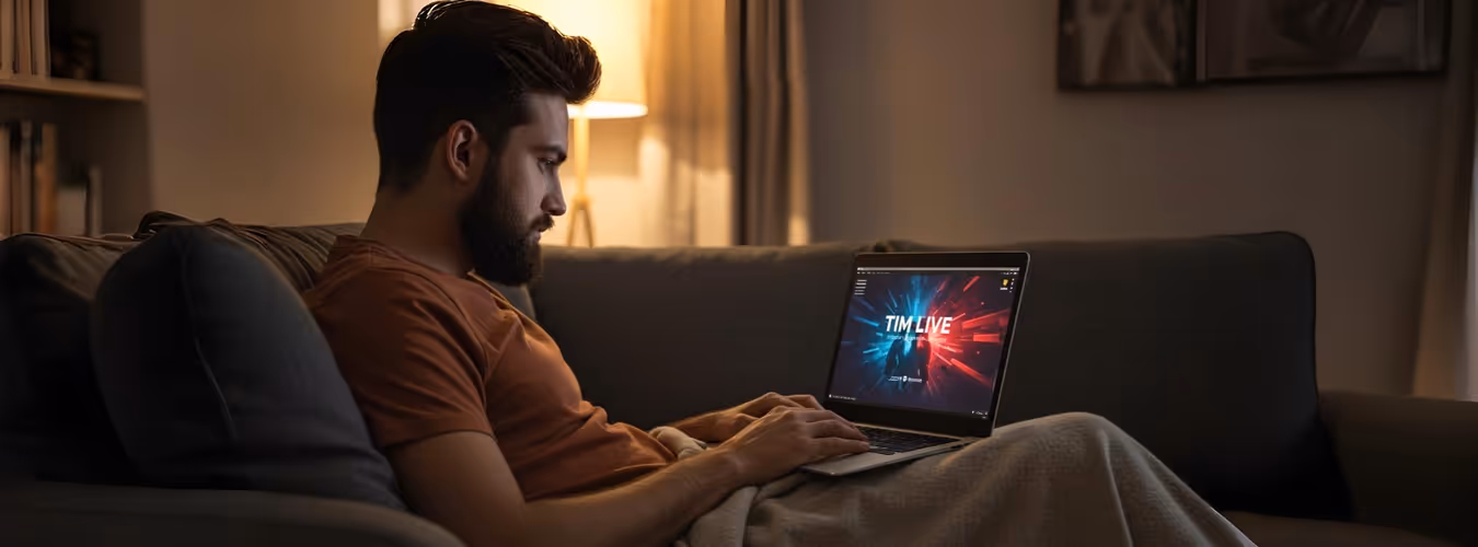 Homem usa notebook com TIM Live em casa à noite