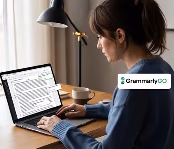 Mulher digitando no laptop com GrammarlyGO aberto na tela.