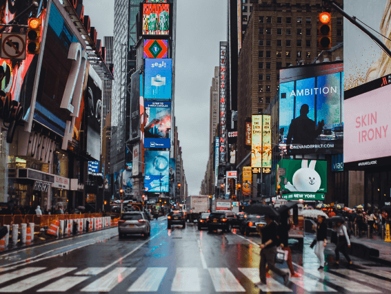 A photo of people walking through Times Square in the rain
