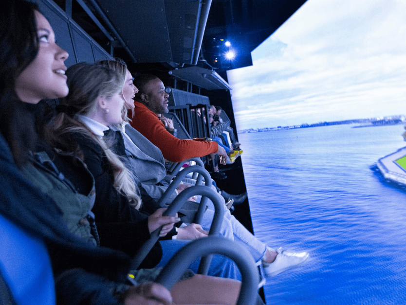 A photo of people looking in amazement as the ride the 4D attraction at RiseNY