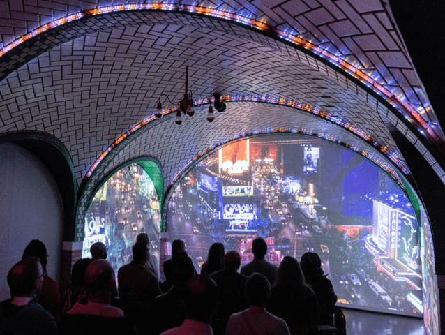 The inside of the RiseNY attraction, a screen showing a film.