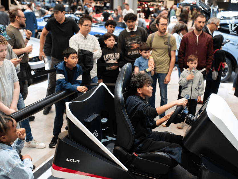 An image of a child driving a simulation car at the New York International Auto Show