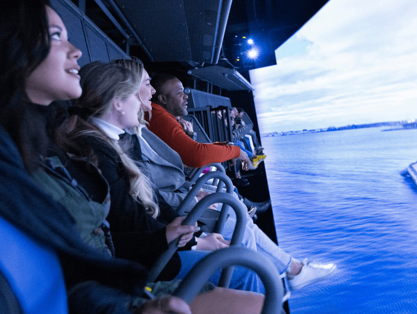 People smiling and enjoying riding the attraction at RiseNY