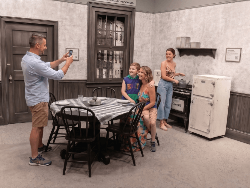 A family smiling and posing for a photo at one of RiseNY's many exhibits