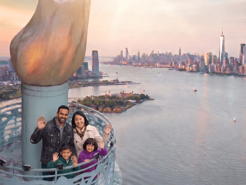 A family posing for a photo, smiling as they pose at the torch photo opp at RiseNY