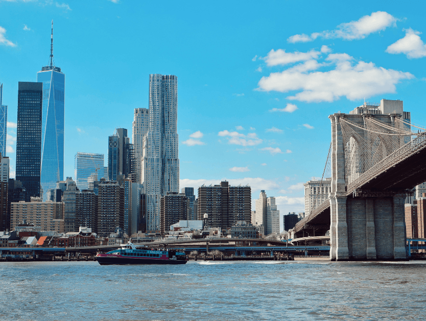 A picture of the New York City skyline, a ferry on the Hudson River, and a partial view of the Brooklyn Bridge