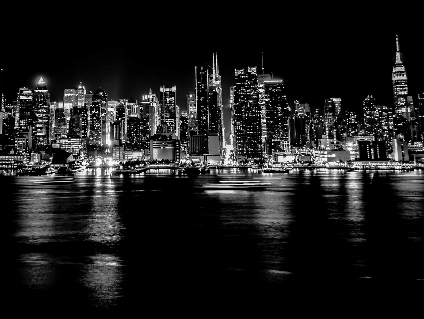 A black and white photo of the Brooklyn bridge at night