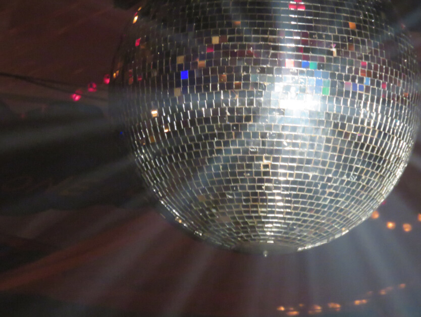 A disco ball on a ceiling with light reflecting off of it
