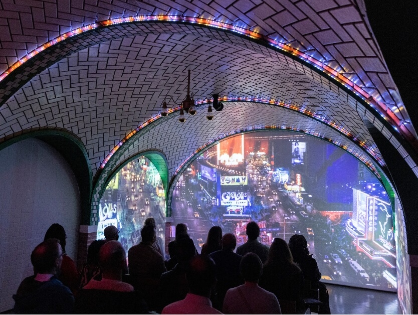 The inside of a section of RiseNY where it shows a video of the history of the subway and New York City