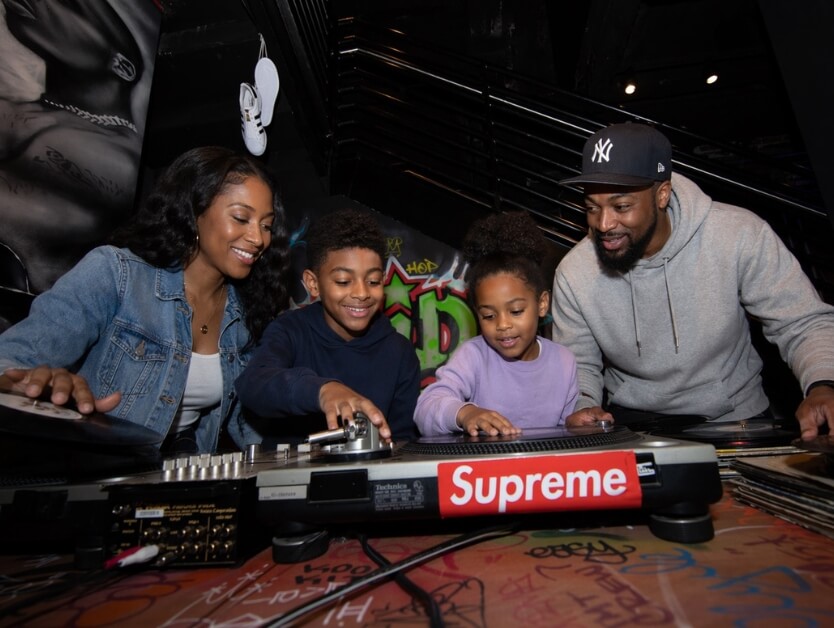 A family enjoying one of the many exhibits at RiseNY and posing with a DJ deck