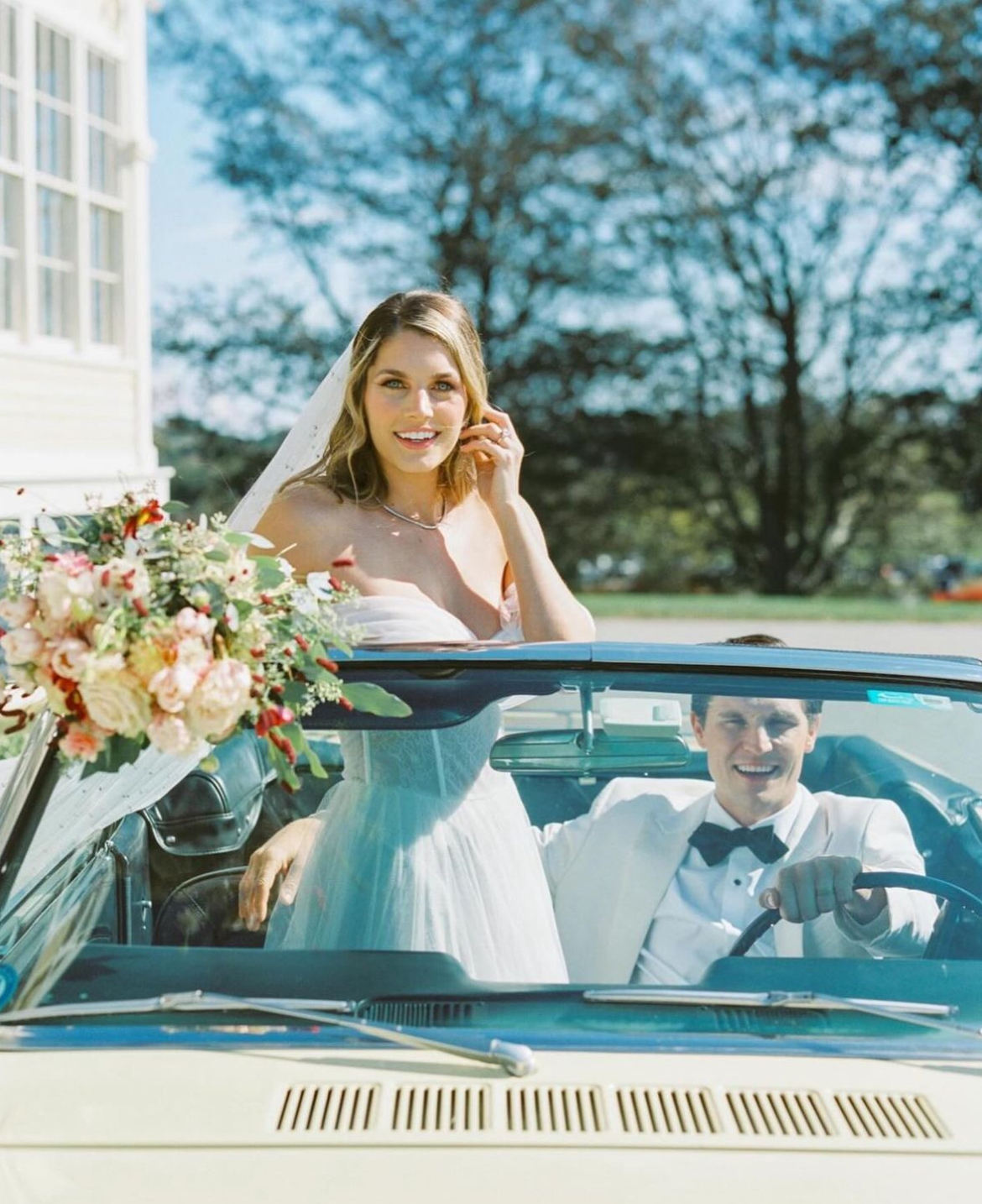 1966 Ford Mustang convertible in pale yellow parked in front of a historic stone mansion in Newport, RI – classic car rental for weddings, events, and photo shoots.
