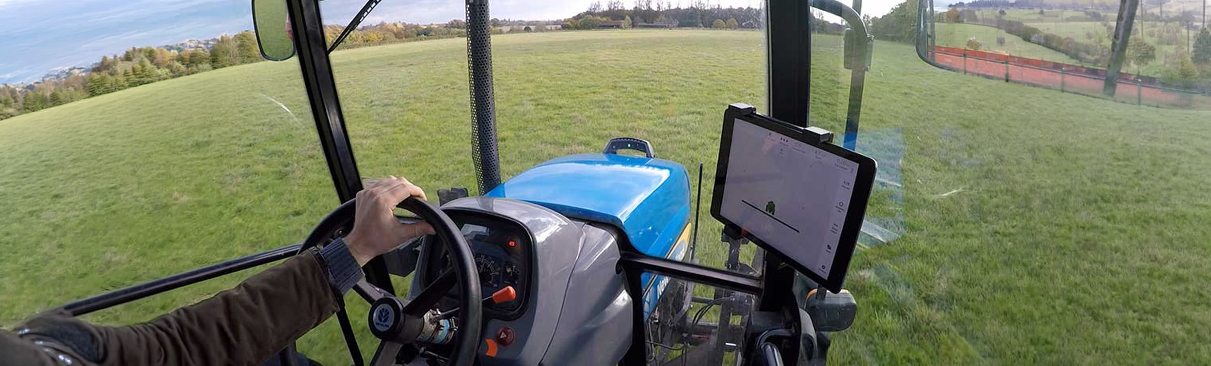 Farmer driving a tractor with the onTrak GPS guidance display in the cab