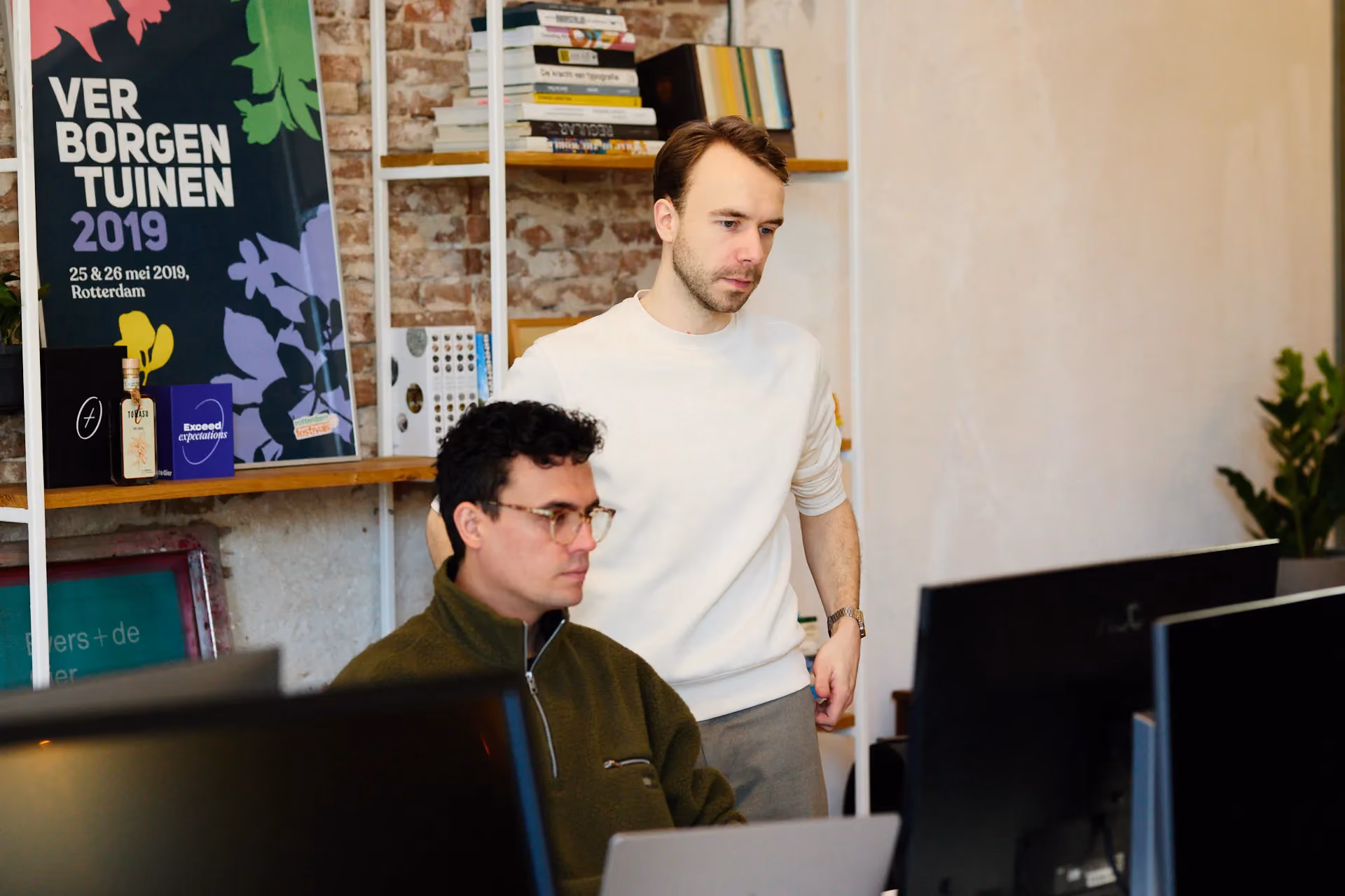 Designers van branding agency Evers + de Gier kijken naar een scherm
