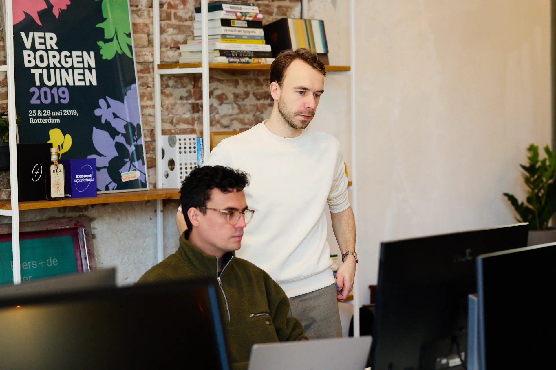 Designers van branding agency Evers + de Gier kijken naar een scherm