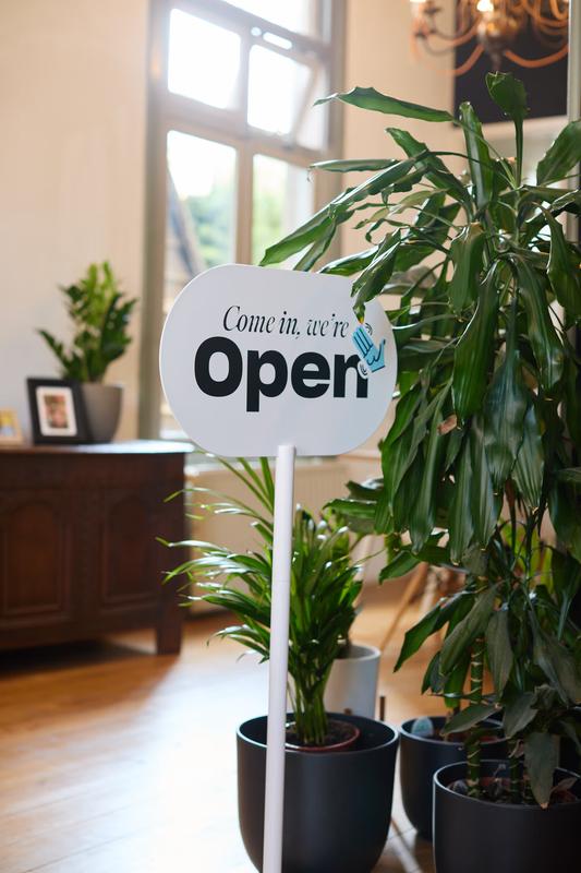 Ingang van de Evers + de Gier studio met 'Come in, we're Open' bord en weelderige planten