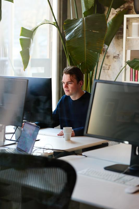 Hidde Collee aan het werk achter zijn bureau met meerdere schermen in de Evers + de Gier studio