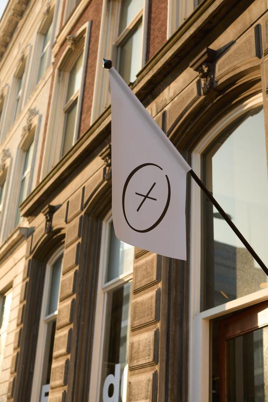 De witte E+dG vlag met het merklogo aan de gevel van de studio