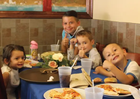 KIDS ENJOYING BIG SLICE ITALIAN FOOD