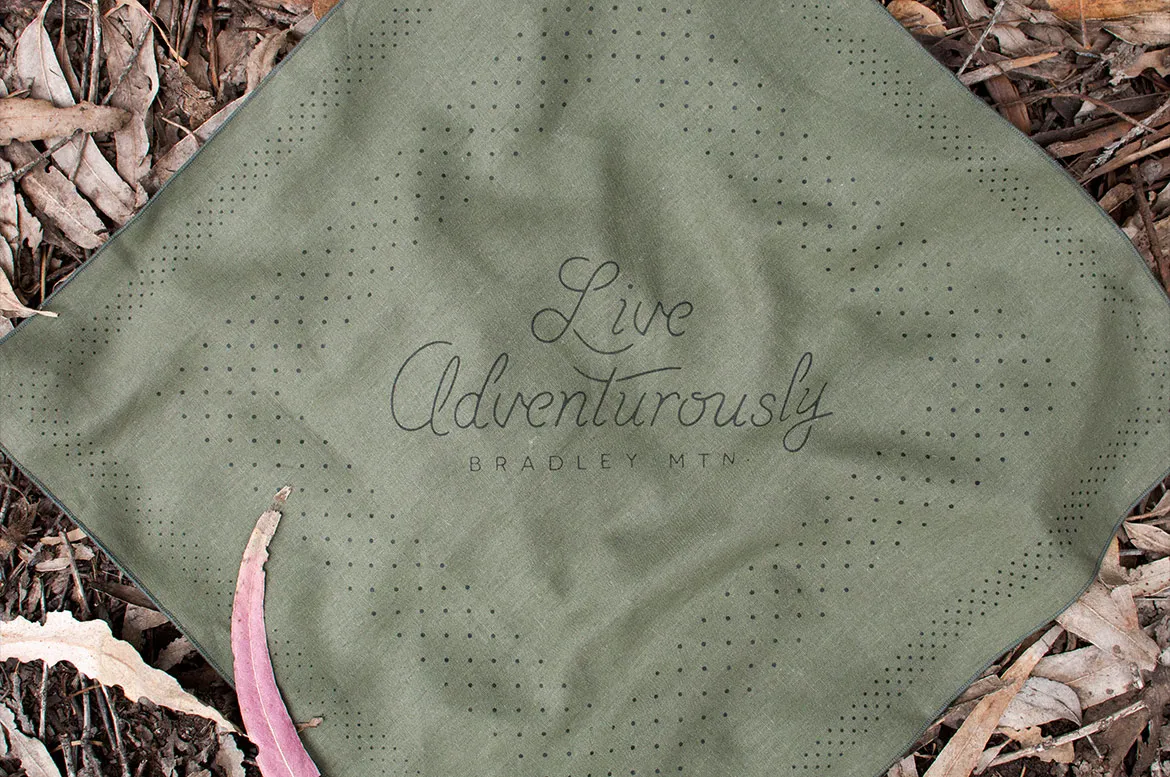 Bradley Mountain's Wind bandana in green, printed with the words Live Adventurously