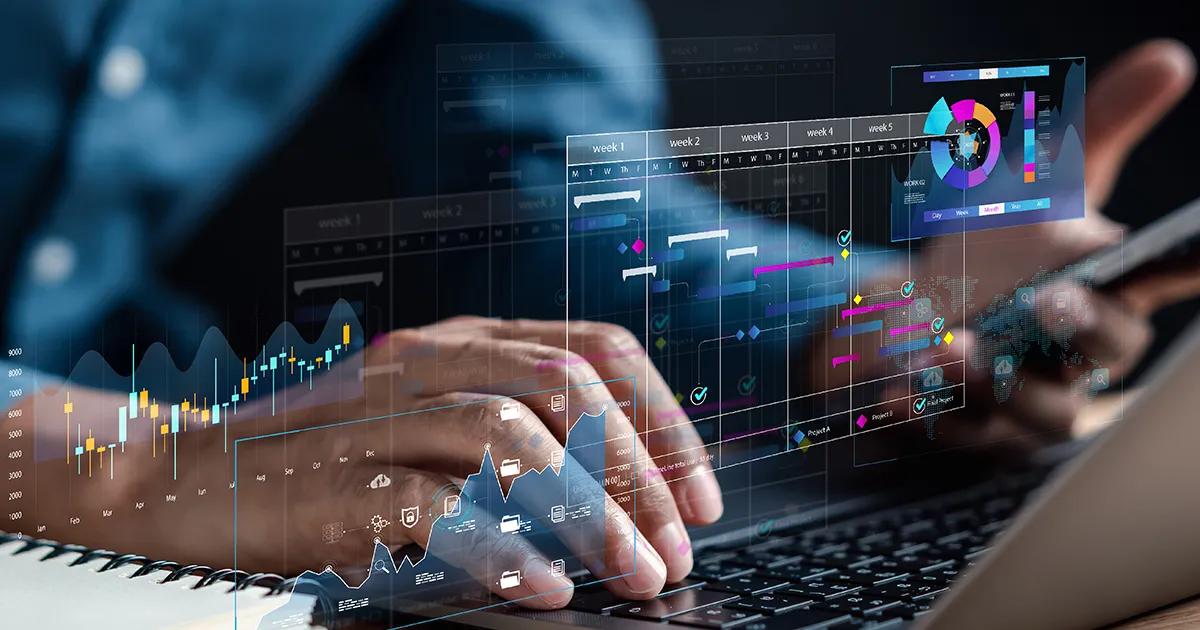 Someone typing on a computer with digital overlay of graphs