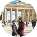 Two female students in front of a monument, visiting for their school trip