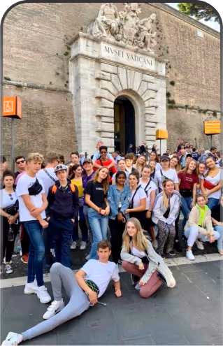 a group of people standing and sitting in front of a building on an educational tour