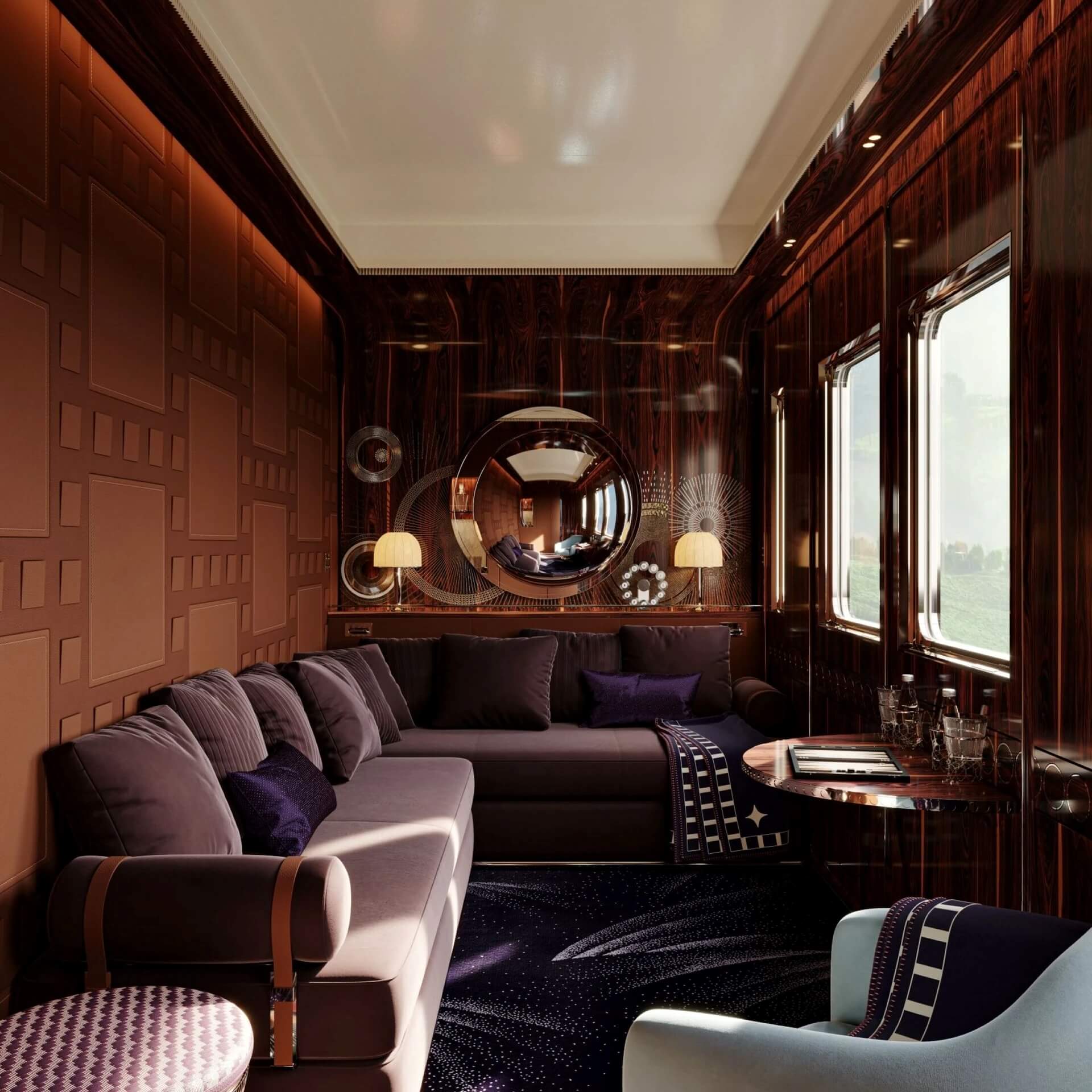 Wide-shot of a L'orient Express suite during the day, features a sofa, as well as luxurious and intricate funishings.