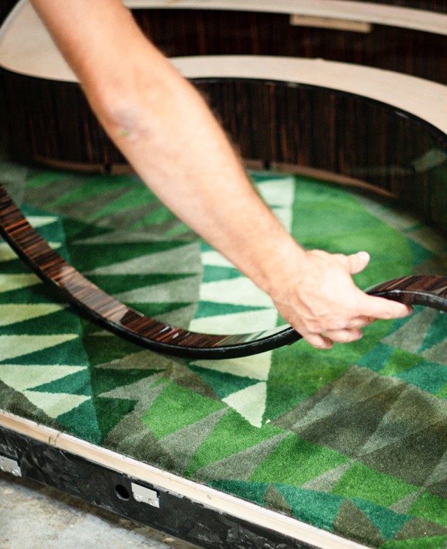 Person constructing a piece of cabinetry for the L'Orient Express' bar car.