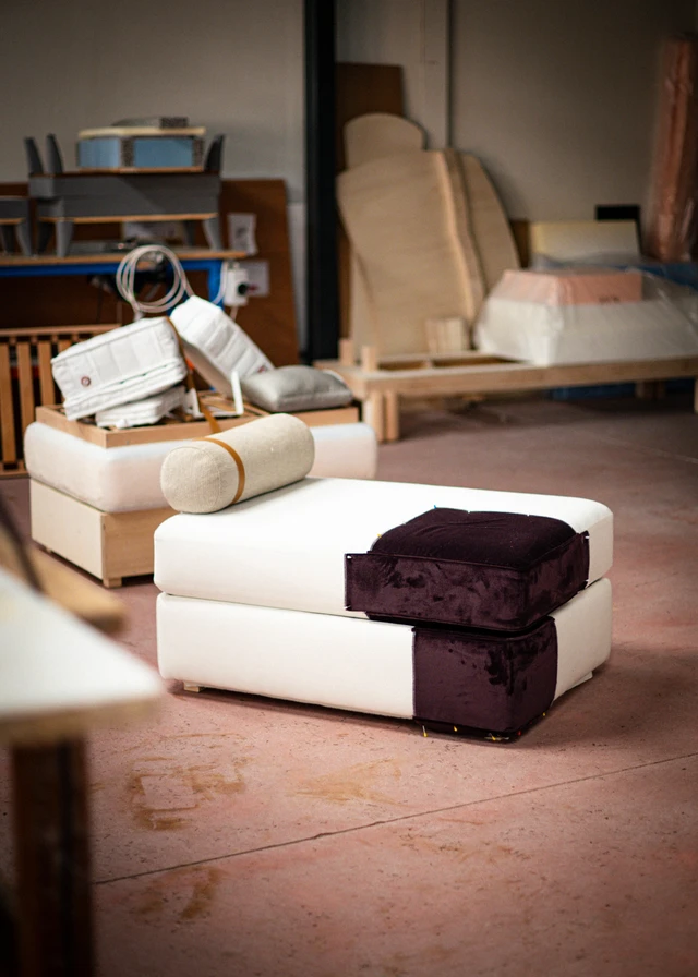 An unfinished settee being upholstered in a workshop studio.