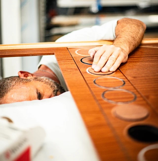 A person constructing and assembling furnishing elements of L'Orient express.