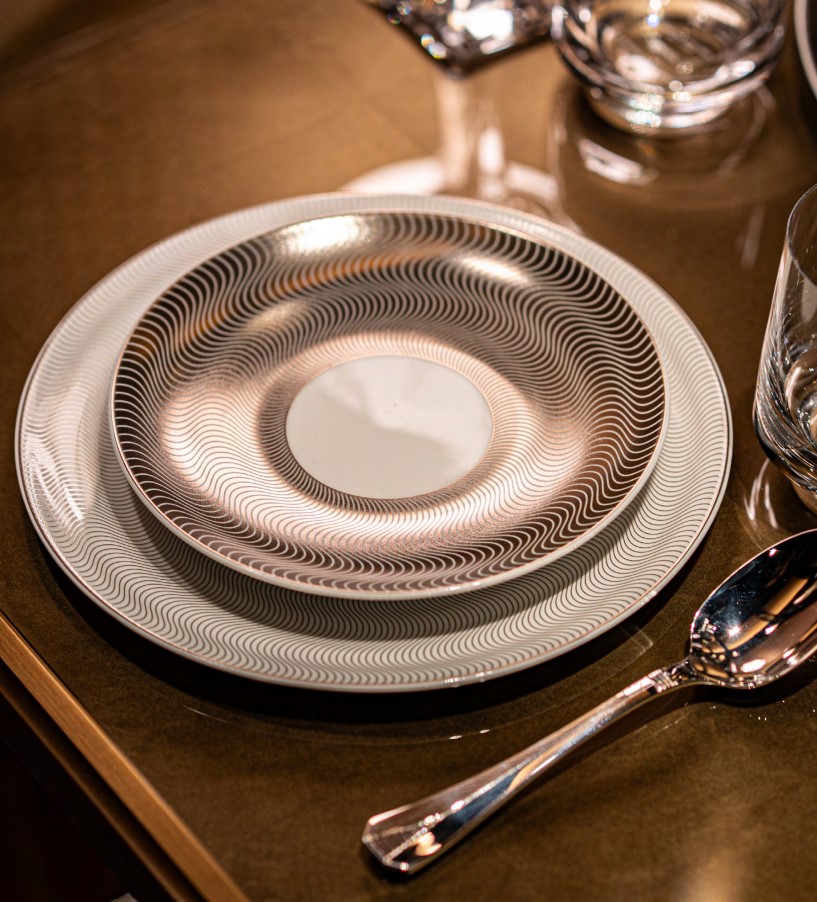 Stacked plates with abstract wavy design set on a table.
