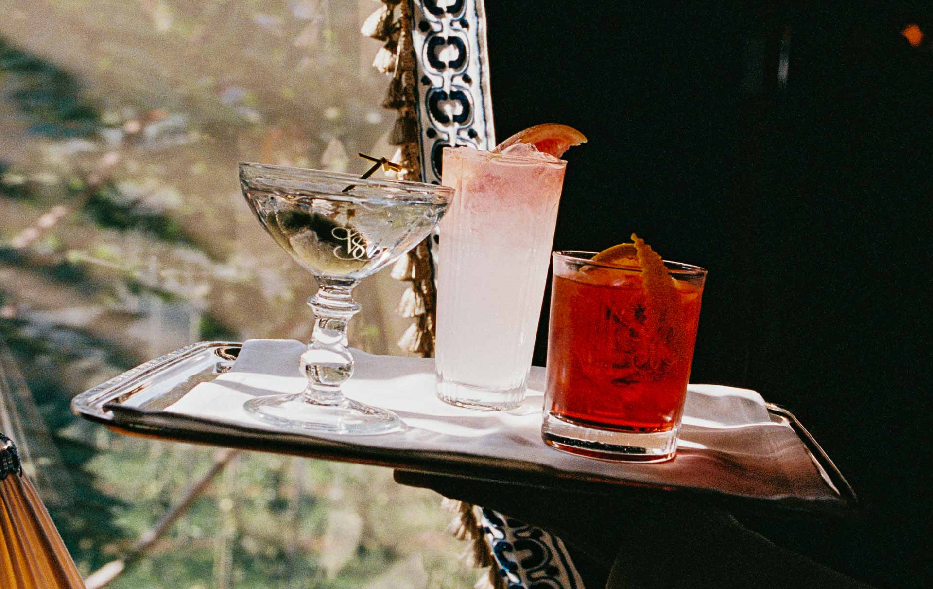 A silver tray with three different cocktails.