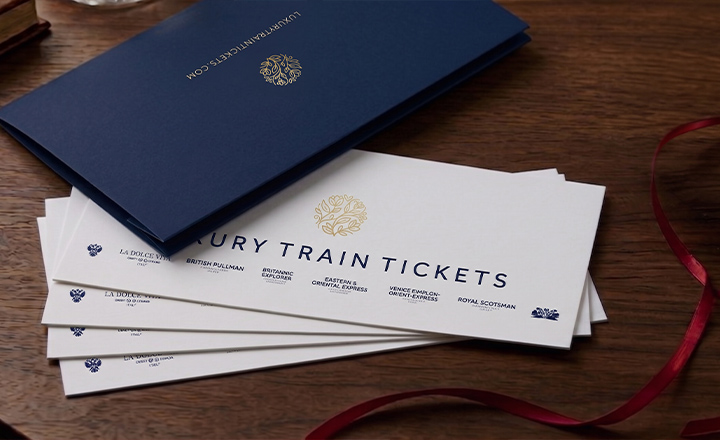 A spread of elegant gift vouchers peeking out from under a navy card voucher wallet.