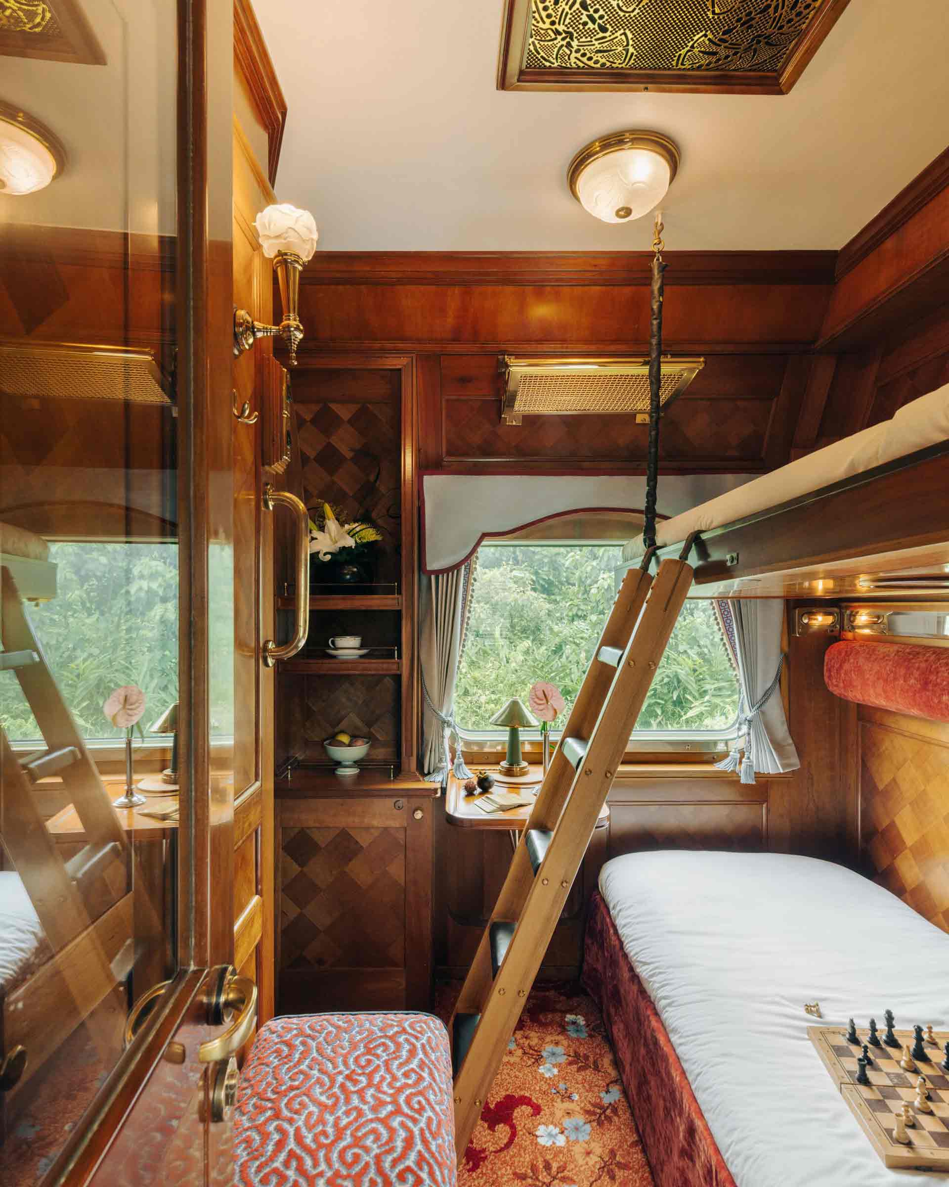 Eastern and Oriental Express' Pullman Cabin ready for rest - shows bunk bed on the right and seating on the left.
