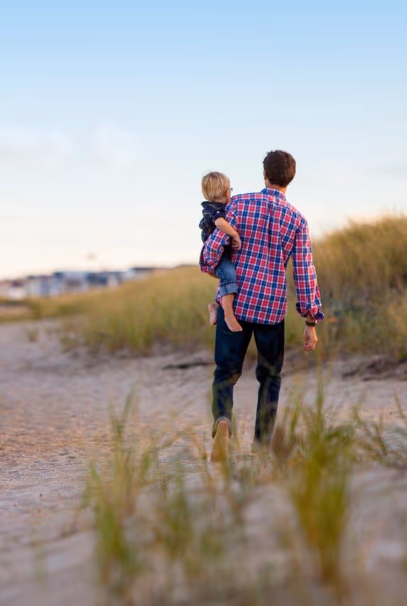 Dad on beach holding child