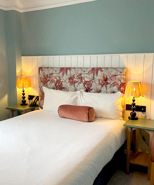 Close up of bartender pouring a double measure  into a cubed glass with ice in a moody setting.