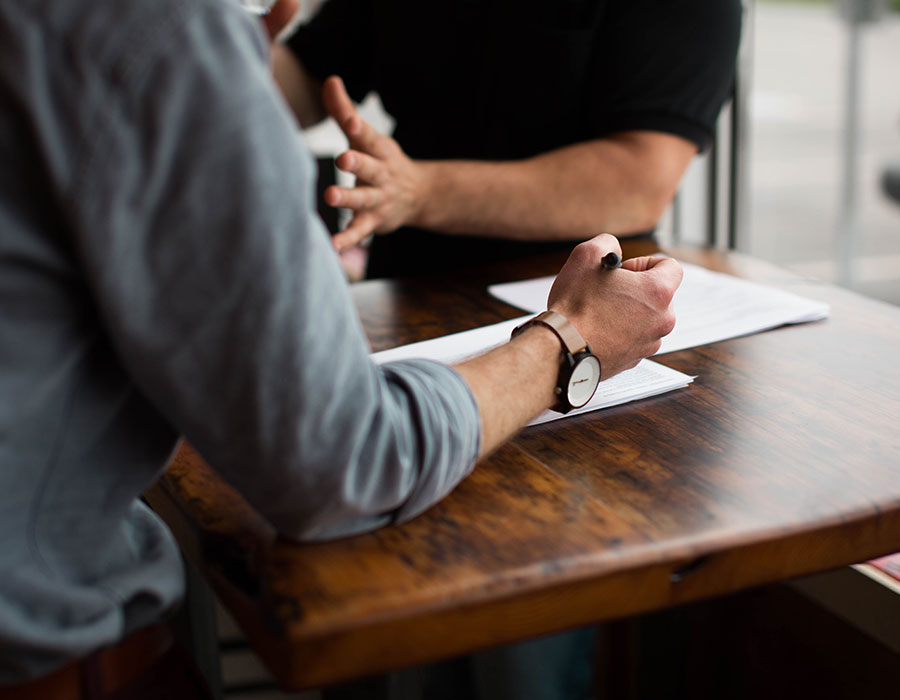 two people working at a wooden desk