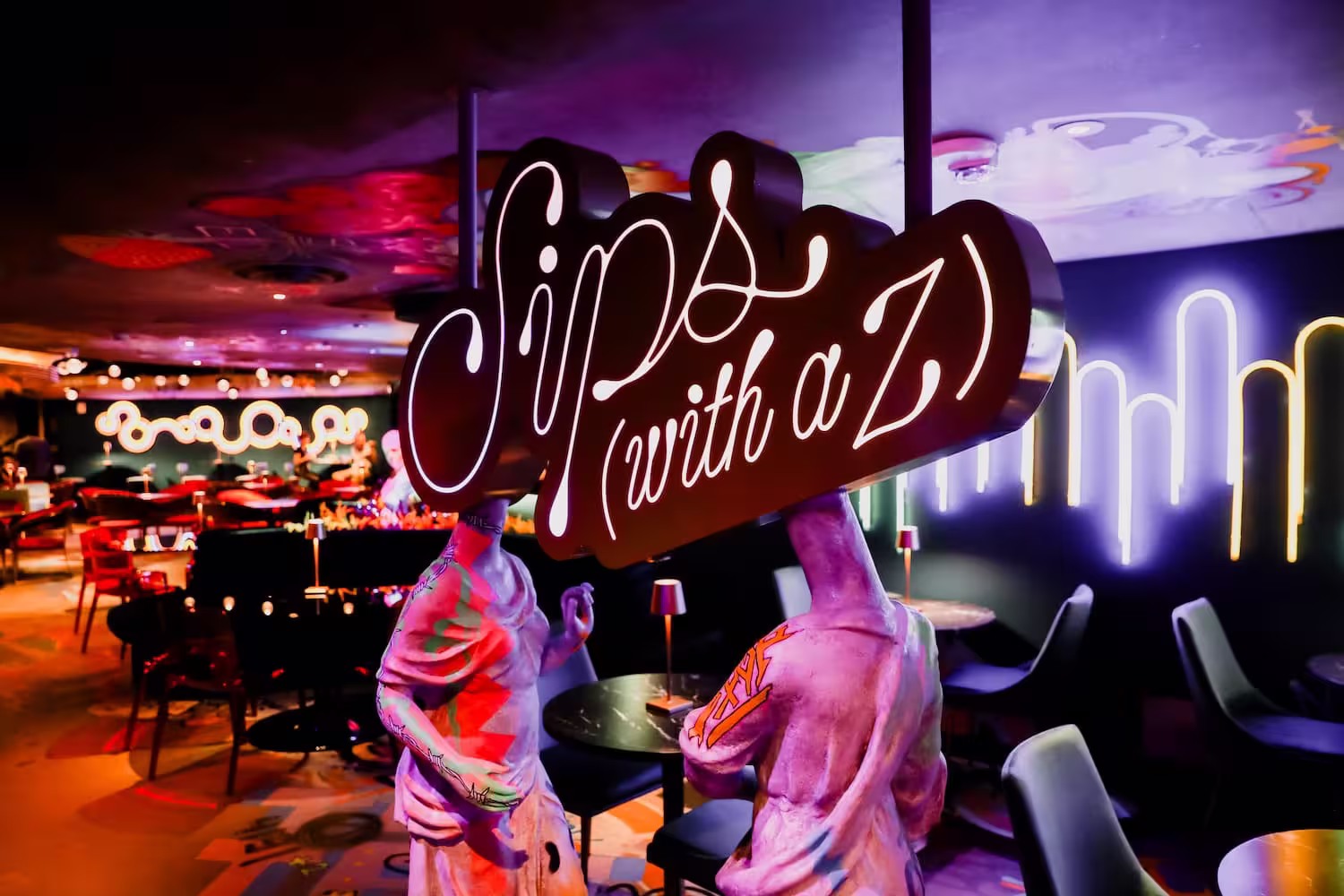 Sign that says "Sips (with a Z)" next to a mannequin inside Meow Wolf Denver